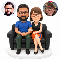 custom bobblehead figures casual couple seated together on a rolled-arm sofa with the man in a T-shirt and trousers and the woman in a cropped top and skirt