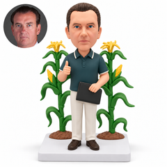 Man giving a thumbs up while holding a portfolio, framed by two sculpted corn stalks with yellow cobs.