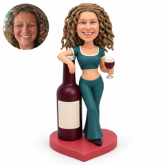 custom bobblehead figure female leaning on an oversized bottle while holding a foamy goblet