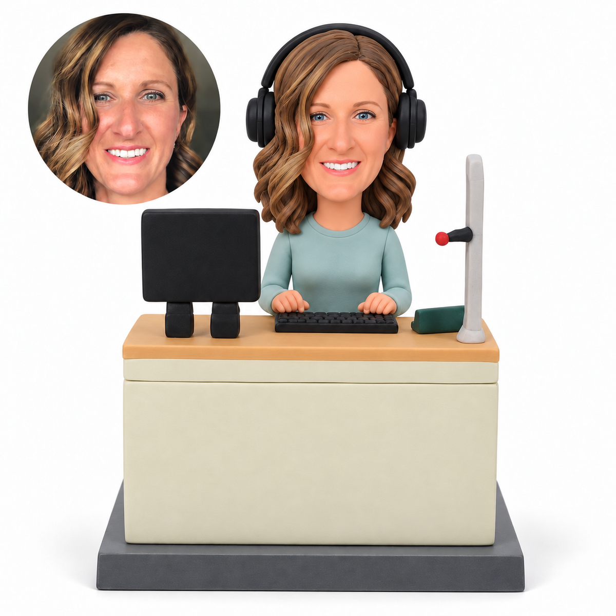 Custom female radio host clay bobblehead wearing a headset and typing behind a studio console