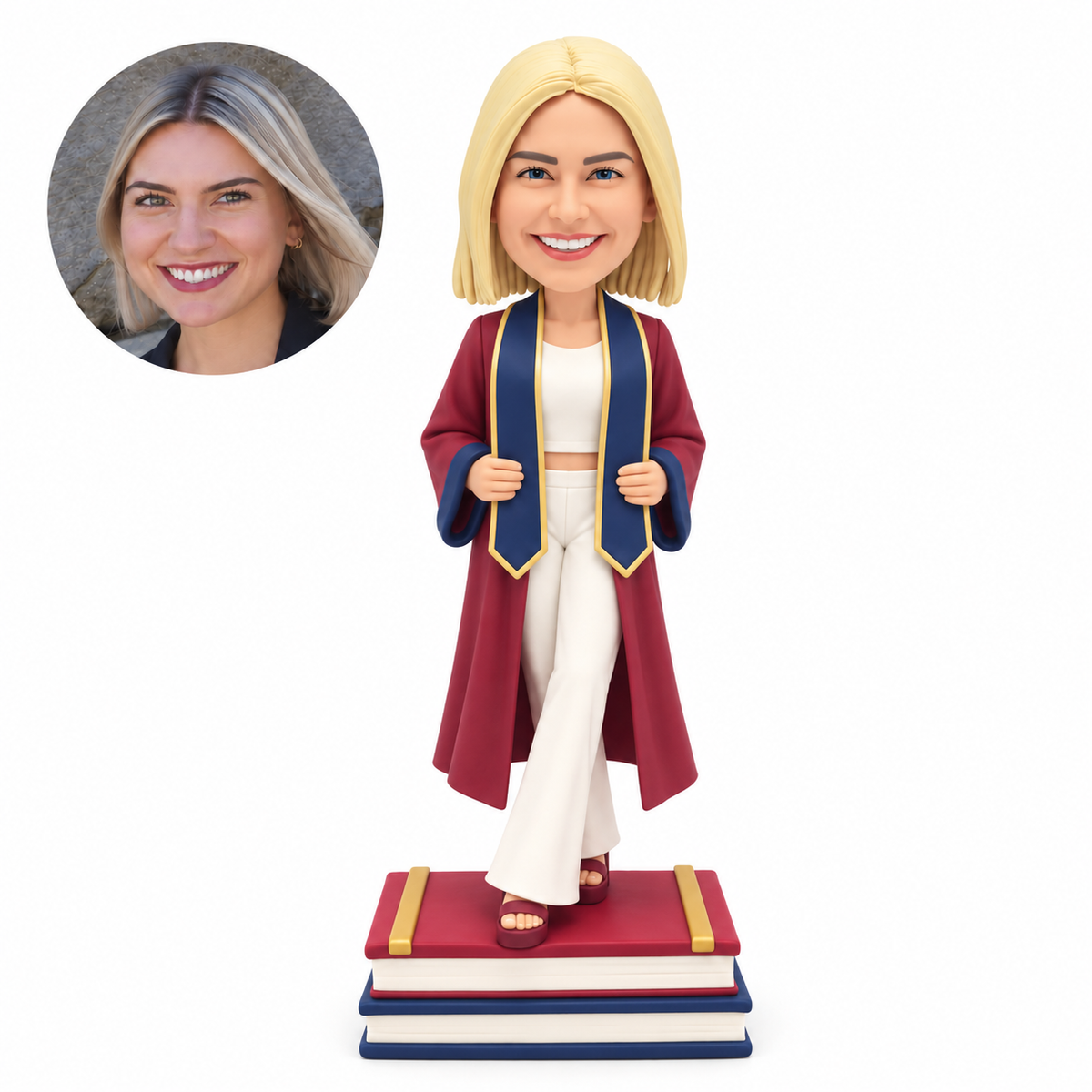 custom bobblehead figure female graduate in an open gown and trousers gripping her stole on stacked books