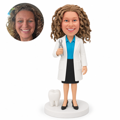 custom bobblehead figure female dentist holding forceps beside a tooth model